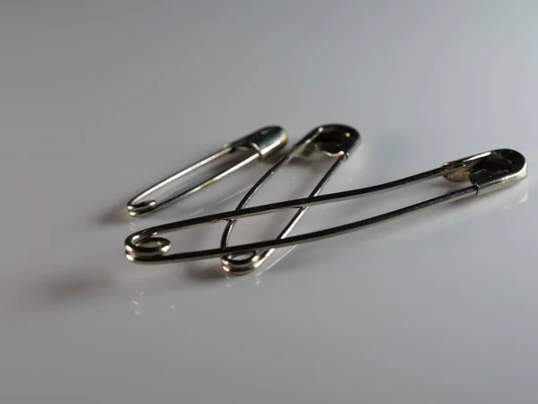 Closeup Safety Pins Gray Surface Lights Blurry Background — Stock Photo, Image