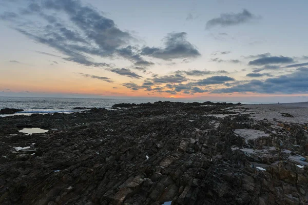 Zbliżenie Ujęcie Oceanicznej Plaży Piaskiem Kamieniami Pięknym Zachodzie Słońca — Zdjęcie stockowe