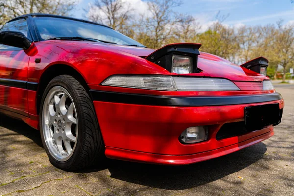 一辆装有隐藏式前灯的现代红色轿车的特写镜头 — 图库照片