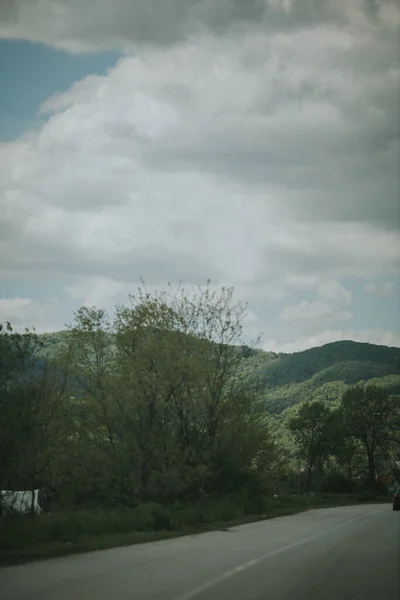 Tiro Vertical Uma Estrada Rural Com Montanhas Arborizadas Céu Nublado — Fotografia de Stock