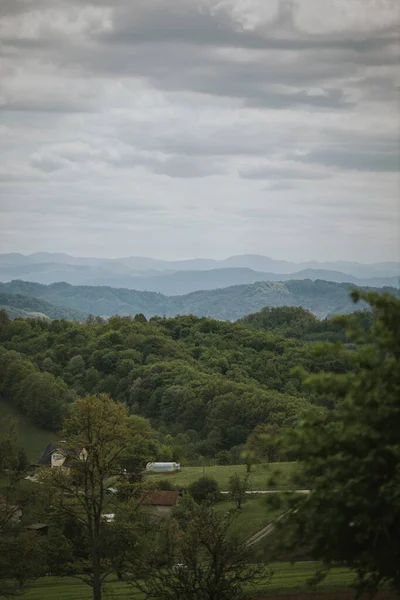 Eine Vertikale Aufnahme Eines Dorfes Grünen Wald Unter Wolkenverhangenem Himmel — Stockfoto