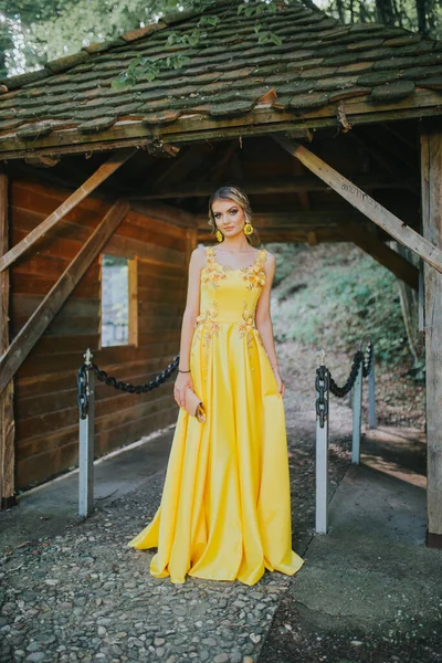 Wspaniała Blondynka Eleganckiej Żółtej Sukience Pozująca Obok Drewnianego Schronu — Zdjęcie stockowe