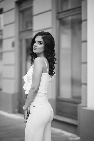 在一座城市建筑的背景上 一个穿着雅致服装的漂亮女性的灰白比例 — 图库照片
