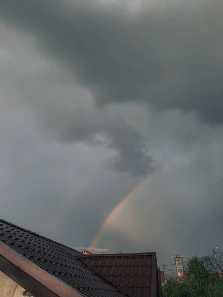 在一幢房子的屋顶上 一幅迷人的彩虹在多云的天空中的景象 — 图库照片