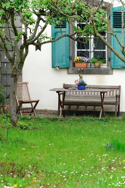 Eine Vertikale Aufnahme Von Gartenmöbeln Vor Einem Weiß Gestrichenen Gebäude — Stockfoto