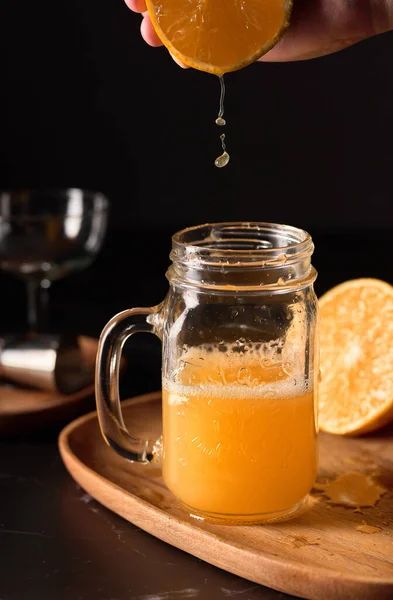 背景にアプライアンスをはめたマゾン瓶ガラスに絞り込まれたオレンジジュースの興味深い垂直浅い焦点ショット — ストック写真