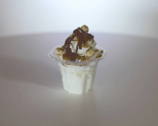 Tiro Close Sorvete Com Propagação Chocolate Avelãs Uma Superfície Branca — Fotografia de Stock