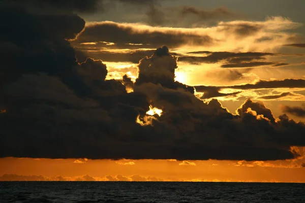 海の上の雲に覆われた黄金の夕日の魅惑的な景色 — ストック写真