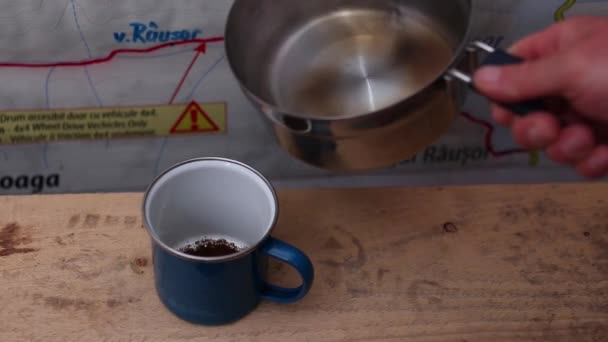 誰かがポットから沸騰した水をカップに注ぎコーヒー粉を入れた映像 — ストック動画