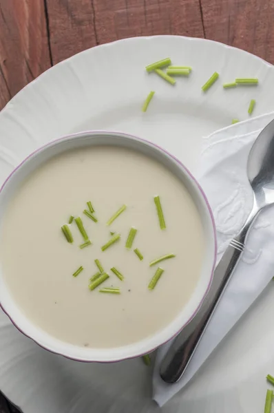 一碗奶油汤与蔬菜放在木制桌子上的垂直镜头 — 图库照片