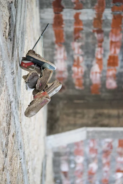 Colpo Verticale Scarpe Appese Bastone Una Parete — Foto Stock