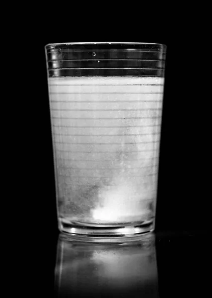 The bubbling soda in glass isolated in black background