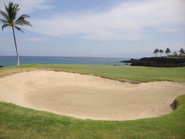 A view of a golf course and sand trap with Waiulua Bay in the background near Waikoloa, on Kona, the Big Island of Hawaii