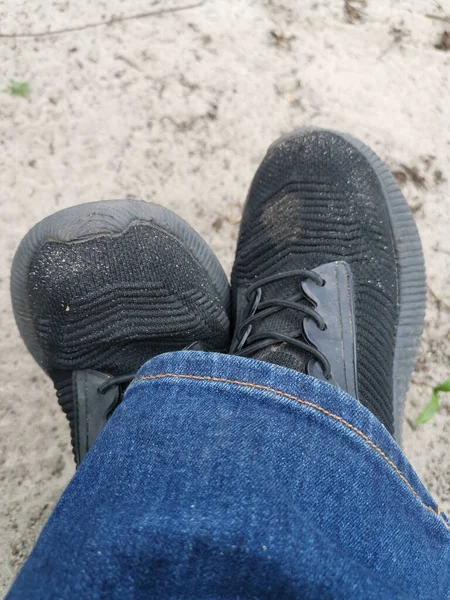 黒い汚れたブーツとジーンズを着た子供の足の垂直ショット — ストック写真