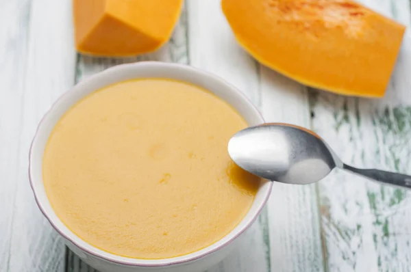 一个健康的南瓜奶油汤在一个碗里用勺子 — 图库照片