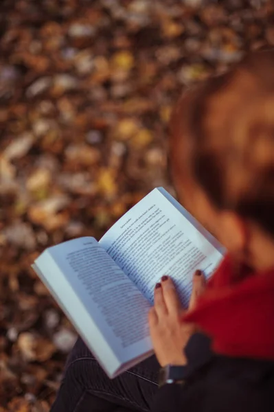 Foco Superficial Uma Mulher Lendo Livro Com Folhas Outono Chão — Fotografia de Stock