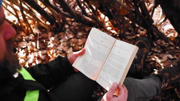 Vuxen Man Vandrare Sitter Skog Täckt Torkade Blad Och Läsa — Stockvideo