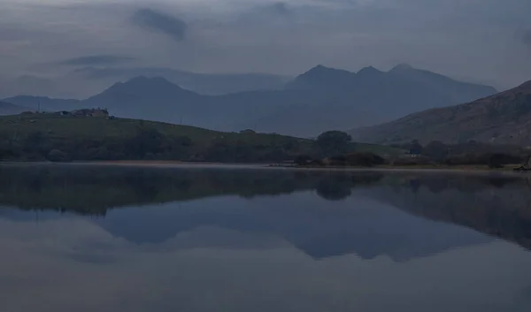 Paisaje Lago Rodeado Colinas Bajo Cielo Nublado Por Noche —  Fotos de Stock