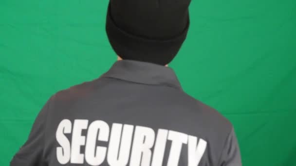 Rearview Walking Male Security Personnel Wearing Black Bonnet Green Wall — Stock Video