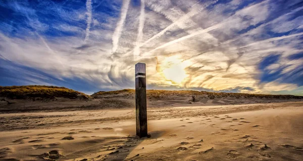 日当たりの良い明るい空の下 砂浜の真ん中にある木の柱の風景 — ストック写真