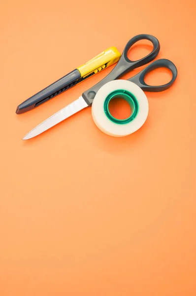 Primer Plano Cinta Adhesiva Tijeras Cuchillo Utilidad Sobre Fondo Naranja — Foto de Stock