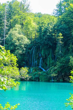A majestic view of waterfalls falling into turquoise lake in Plitvice Lakes National Park, Croatia clipart