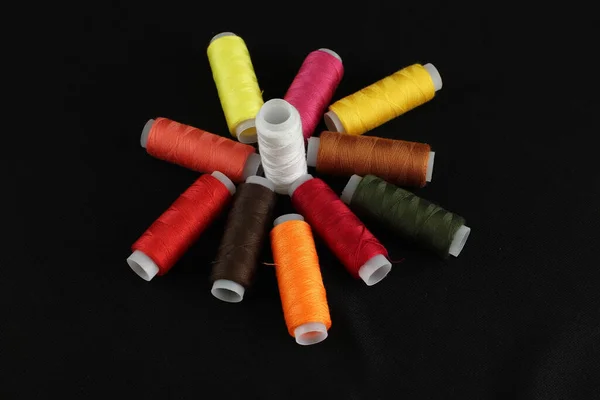 Close Fios Costura Coloridos Dispostos Uma Superfície Preta — Fotografia de Stock