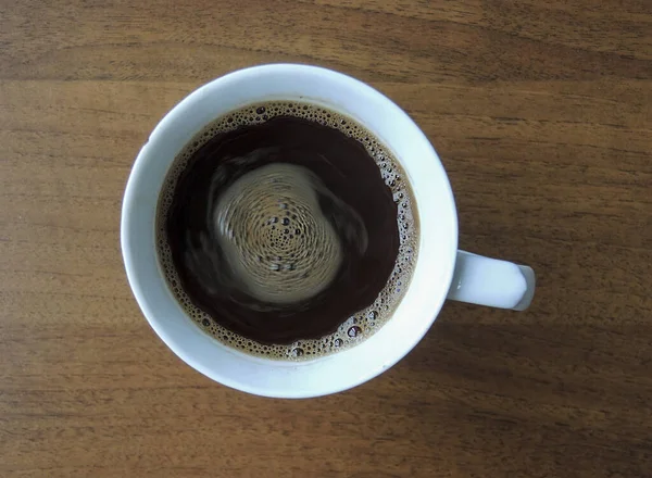Egy Csésze Reggeli Kávé Tetején Benne Örvénylő Folyadékkal Egy Asztalon — Stock Fotó