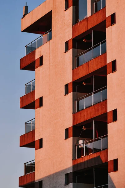 Ένα Κάθετο Πλάνο Ενός Σύγχρονου Πορτοκαλί Πέτρινου Κτιρίου Γυάλινα Μπαλκόνια — Φωτογραφία Αρχείου