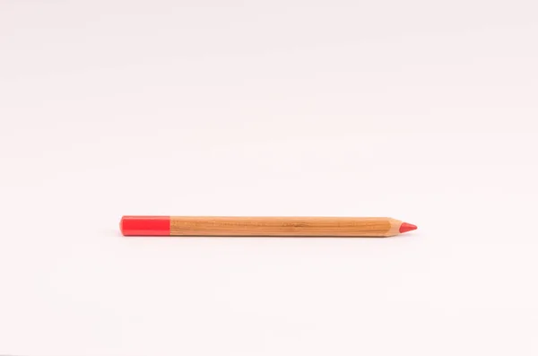 粉红铅笔在浅粉空白处的木制红色铅笔的特写 — 图库照片