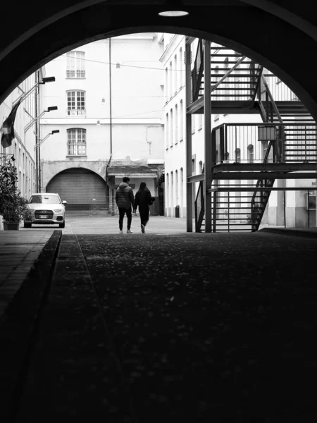 建物の横を歩く夫婦のシルエットのグレースケール — ストック写真