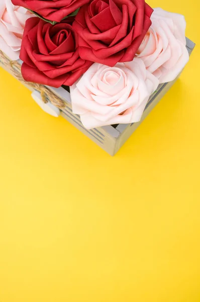 一朵美丽的红白相间的玫瑰在一个黄色背景的盒子里垂直地拍照 — 图库照片