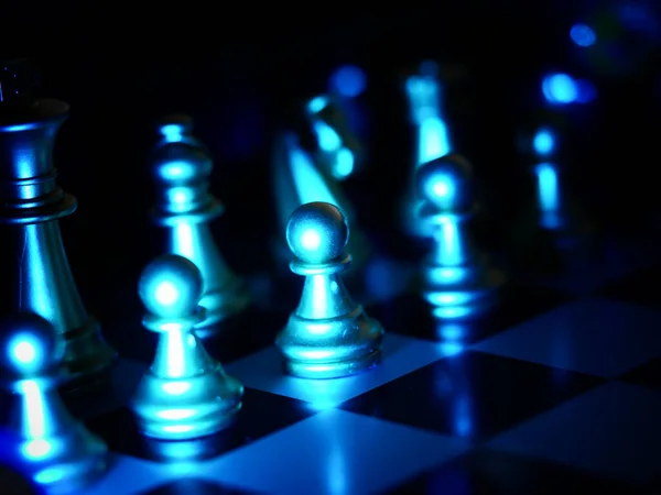 Eine Schachfigur Die Mit Blauem Licht Vor Dunklem Hintergrund Beleuchtet — Stockfoto