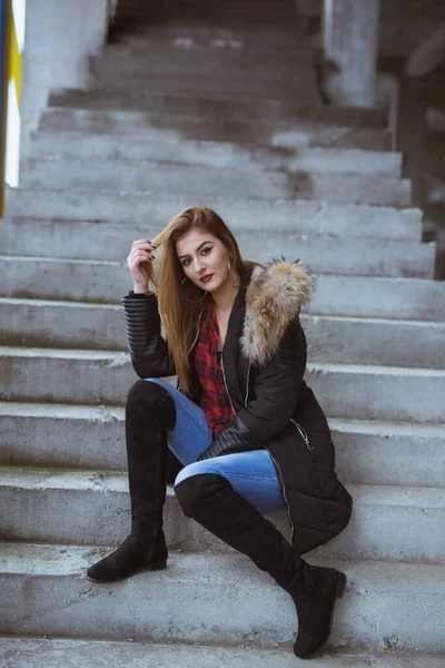 Вертикальний Знімок Молодої Жінки Пальто Довгі Чоботи Позує Сидячи Сходах — стокове фото