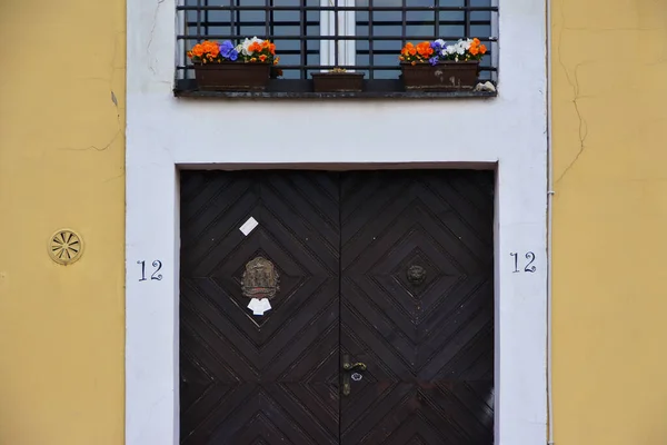 Dobrze Wykonane Ciemnobrązowe Drzwi Numerem Obok Kwiaty Balkonie Powyżej — Zdjęcie stockowe