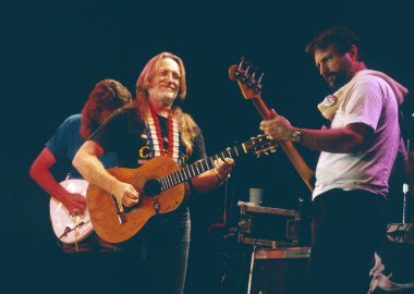 BRANSON, MISSOURI, UNITED STATES - Jun 26, 1992: Willie Nelson and band members perform on stage at the Willie Nelson  Ozark Theater in Branson, Missouri in 1992. clipart