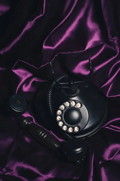 Pionowe Ujęcie Starego Telefonu Jasnym Fioletowym Jedwabnym Tle — Zdjęcie stockowe