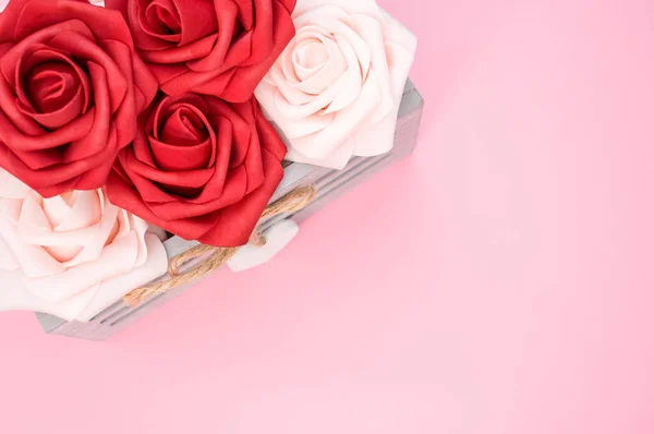 ピンクの背景に隔離された箱の中の美しい赤と白のバラ — ストック写真