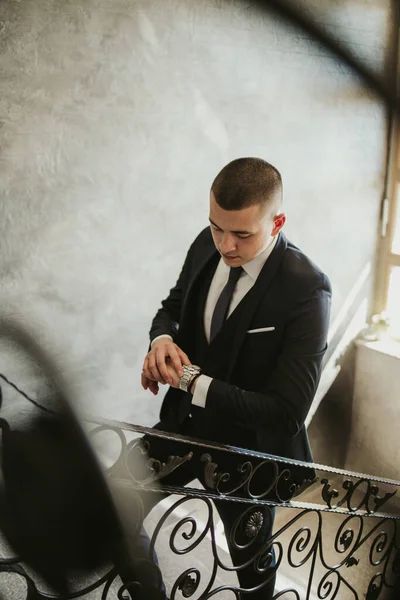 若い魅力的な男性の垂直ショットは 階段にポーズを正式なスーツで — ストック写真