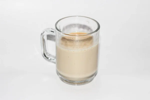 白い背景にミルクが分離されたコーヒーのグラスのクローズアップショット — ストック写真