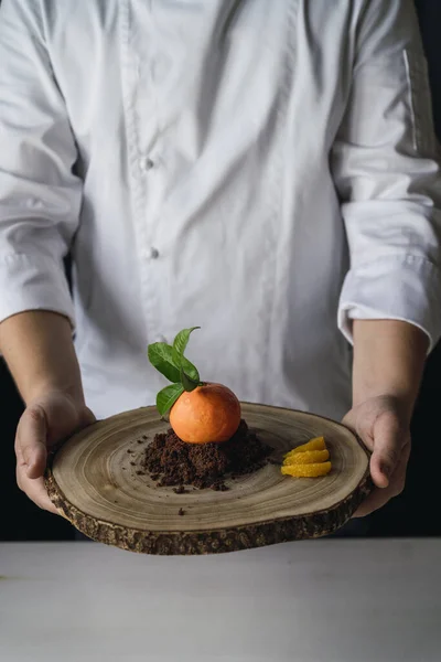 Bir Şef Elinde Çikolatalı Bisküvi Meyveli Mandalina Şeklinde Bir Pasta — Stok fotoğraf