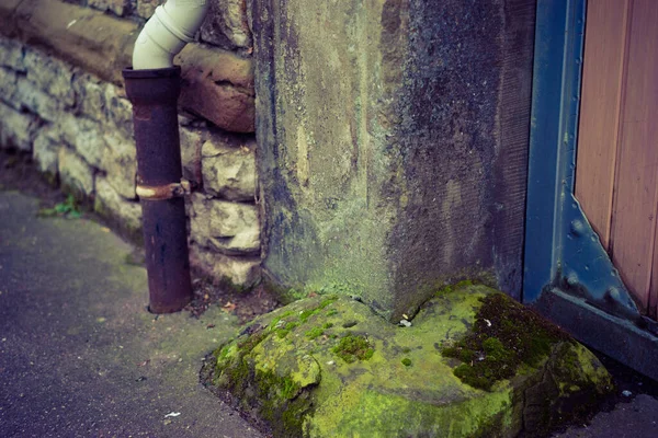 Closeup Shot Sewerage Pipe Next Old Stone Wall Wooden Door — Stock Fotó