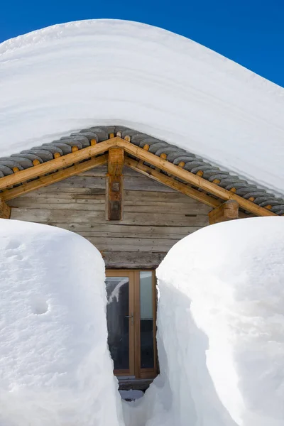 スイスの晴れた日の玄関ドアと雪の家 — ストック写真