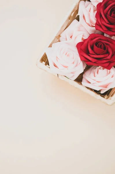 Pionowe Ujęcie Pięknych Czerwonych Białych Róż Pudełku Odizolowanym Beżowym Tle — Zdjęcie stockowe