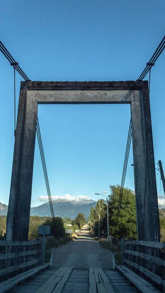 晴れた日に道路上の木製の吊り橋の垂直ショット — ストック写真