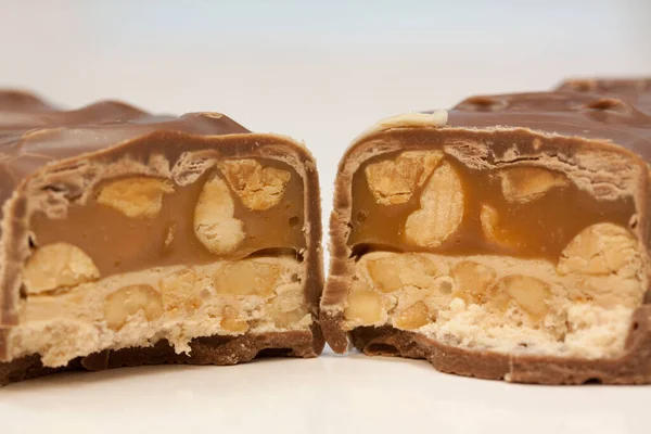 白い背景にピーナッツ入りのおいしいキャラメルチョコレートバーのクローズアップショット — ストック写真