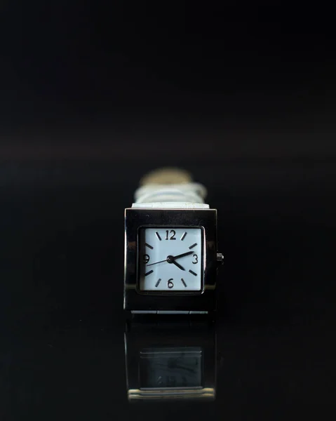 ブラックの背景を持つホワイトバンドの時計の垂直ショット — ストック写真