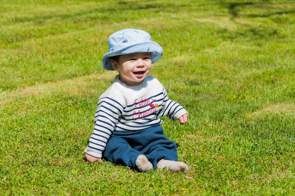 草の上に座っている帽子の中にかわいい幸せな男の子のクローズアップショット — ストック写真