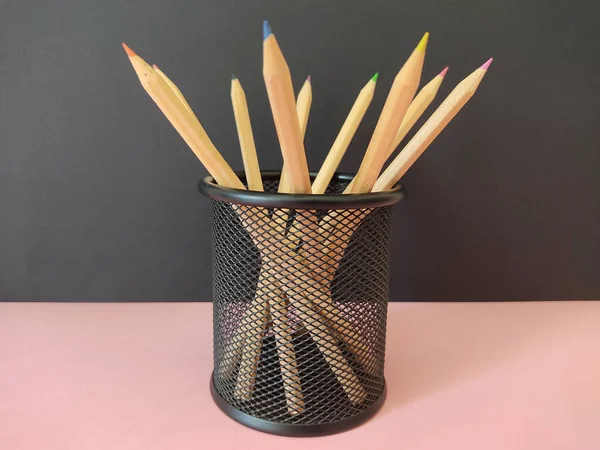Wooden Colored Pencils Mesh Pen Holder Pink Surface Black Background — Stock Photo, Image