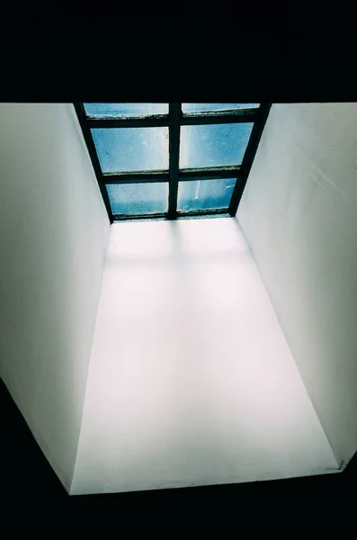 暗い建物の中に太陽光のある窓の垂直ショット — ストック写真